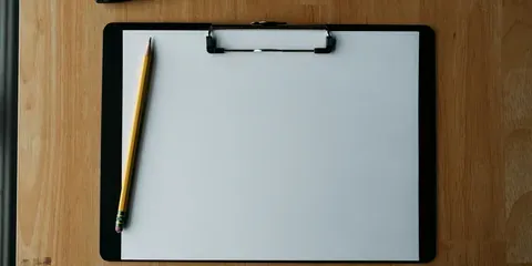 Porte-bloc et crayon posés sur un bureau