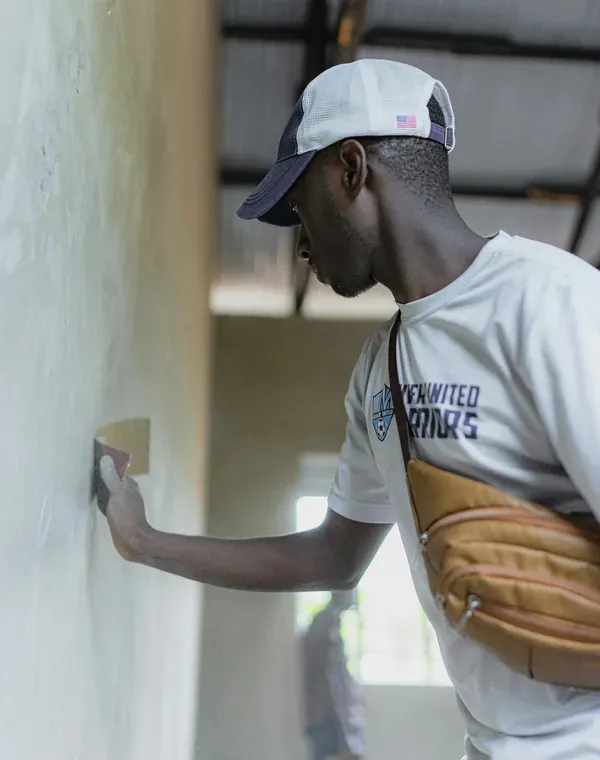 Technicien appliquant un enduit de reprise sur un mur